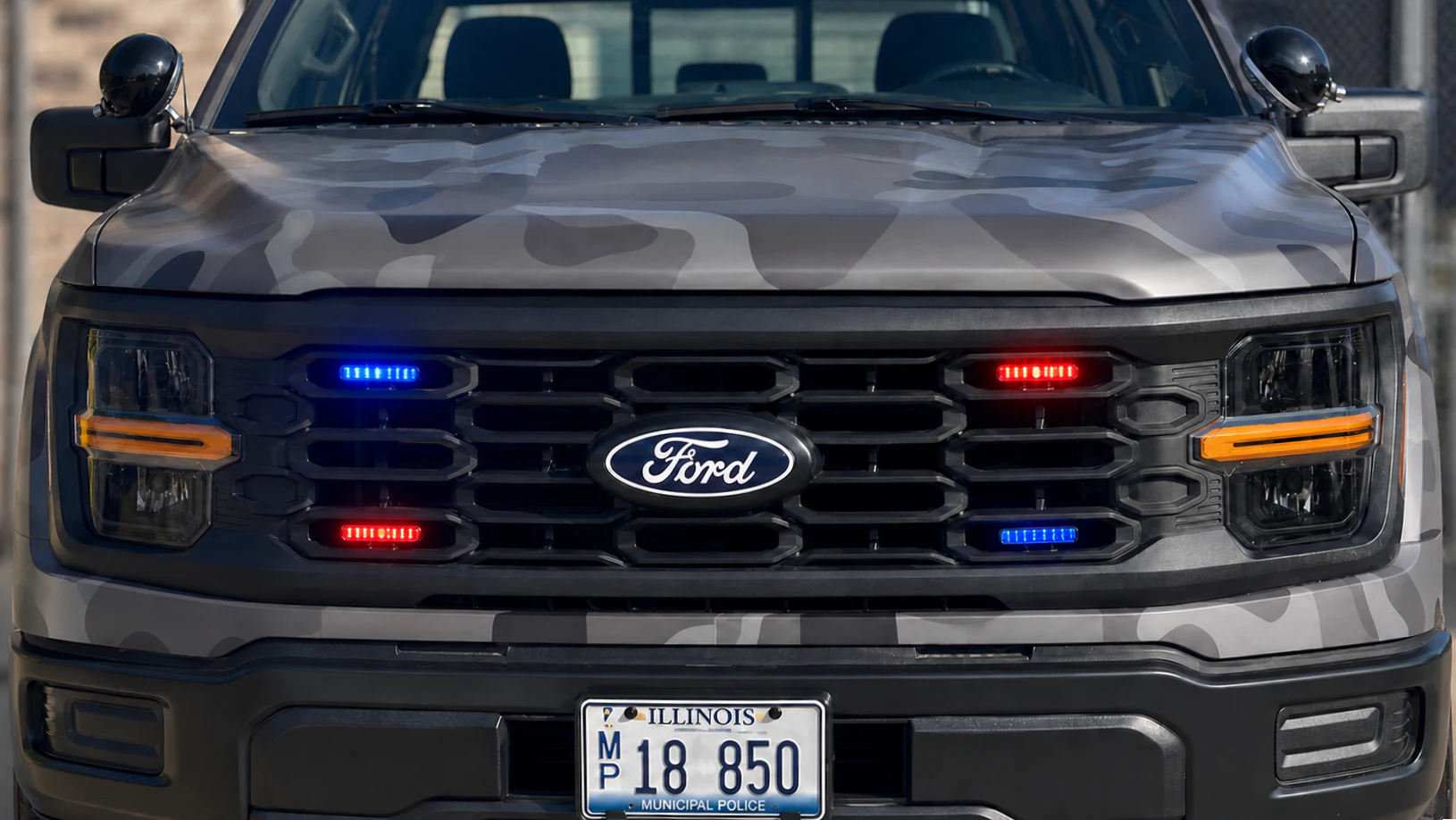 Red and blue emergency lights integrated into a police pickup grille